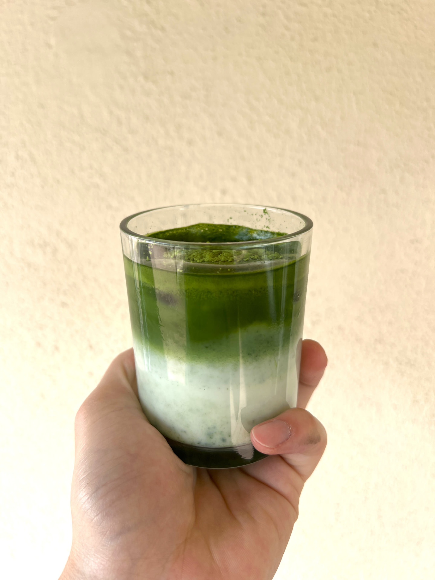 Bright green matcha powder in a white bowl