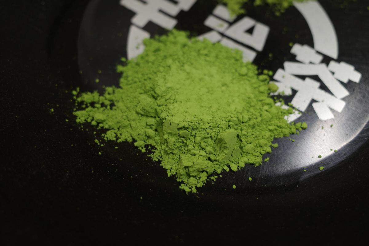 Vivid green ceremonial matcha powder on a black plate