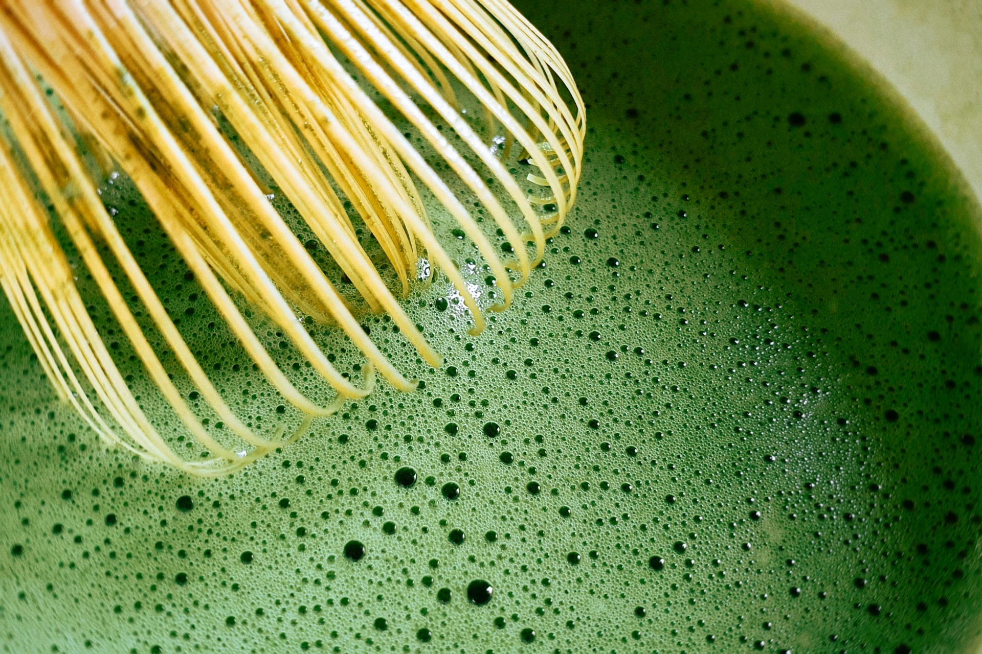 Whisking matcha in a dark bowl